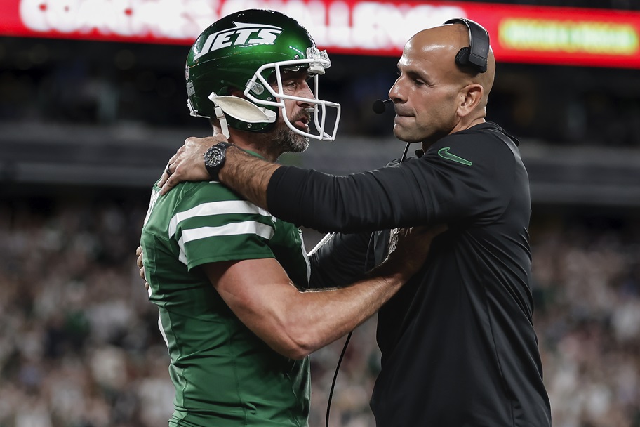 Robert Saleh tries to hug Aaron Rodgers after a touchdown.